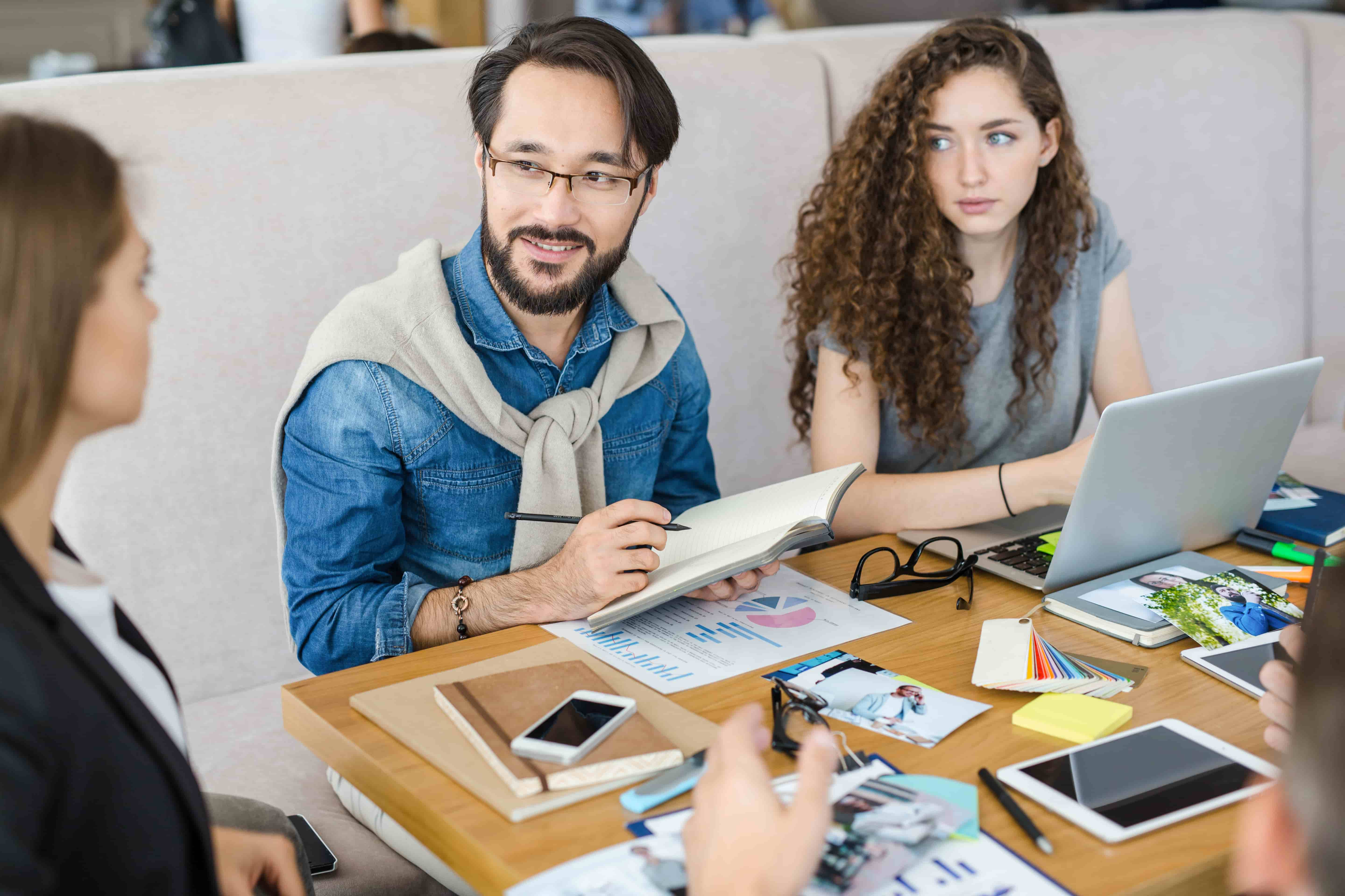 un chico y una chica parte de un programa de practicas profesionales conversan con una mujer empresaria